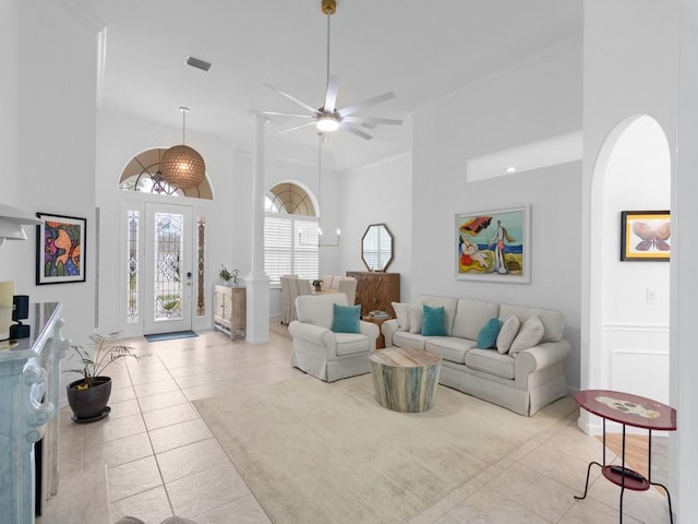 living room featuring light tile patterned floors, ceiling fan, and a high ceiling