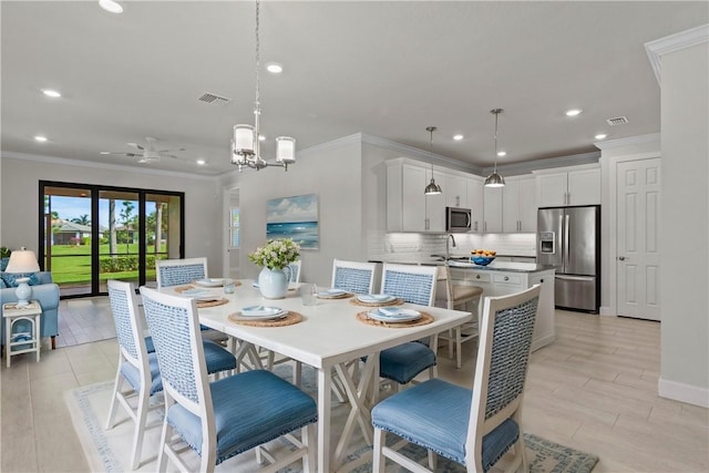 dining space with visible vents, ceiling fan with notable chandelier, and ornamental molding