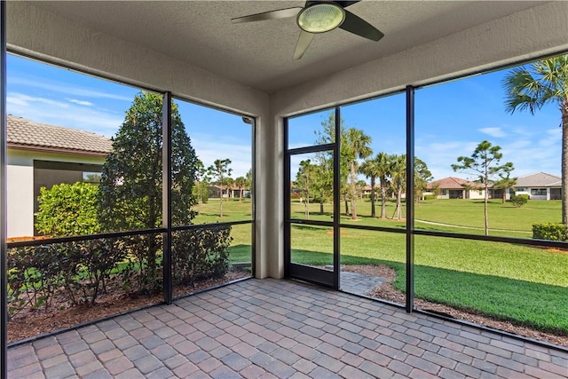 unfurnished sunroom with a ceiling fan and a healthy amount of sunlight