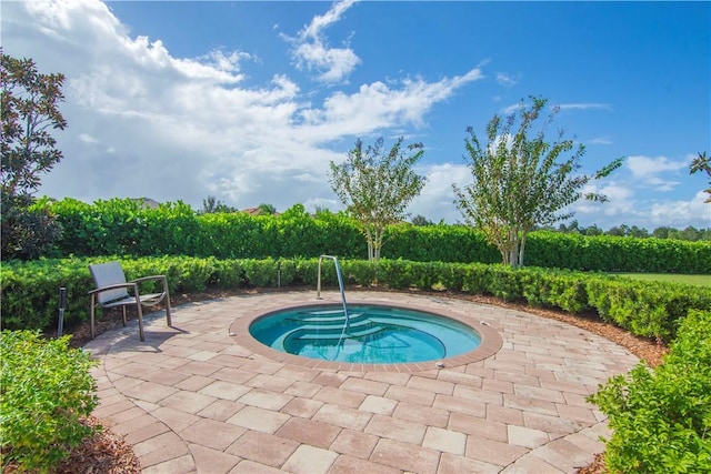 view of pool with an in ground hot tub and a patio