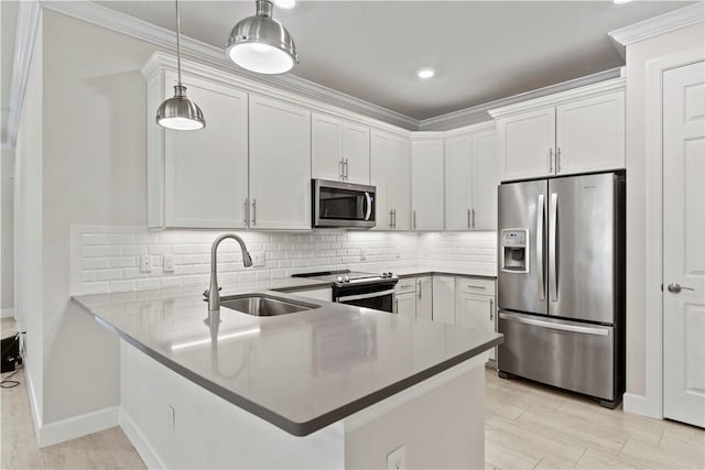 kitchen with tasteful backsplash, appliances with stainless steel finishes, a peninsula, white cabinets, and a sink