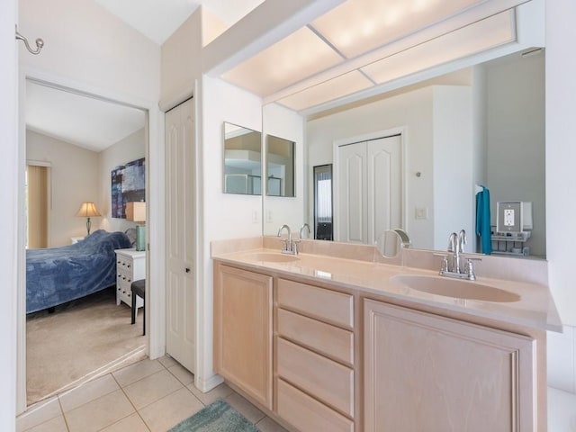 bathroom featuring vanity, tile patterned floors, and vaulted ceiling