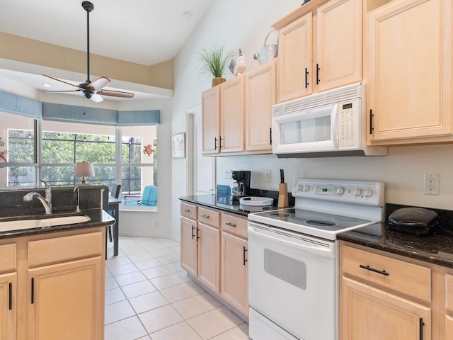 kitchen with light brown cabinets, white appliances, dark stone countertops, and ceiling fan