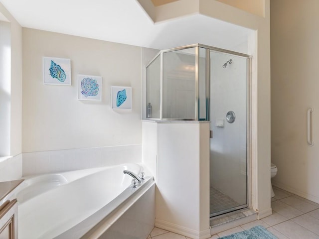 bathroom featuring toilet, tile patterned flooring, and shower with separate bathtub