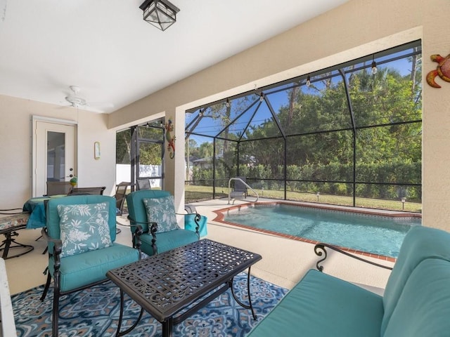 view of swimming pool featuring ceiling fan, a lanai, and a patio