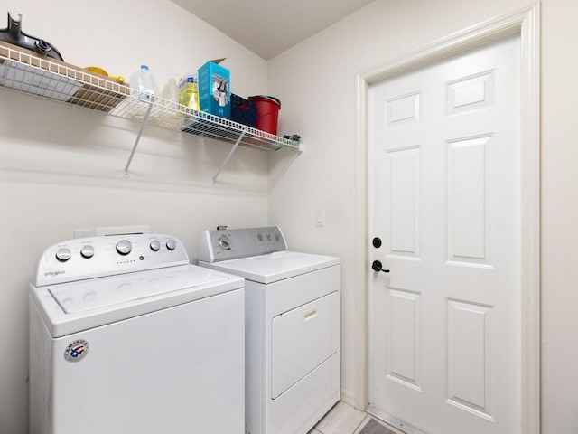 washroom with washer and clothes dryer and light tile patterned floors