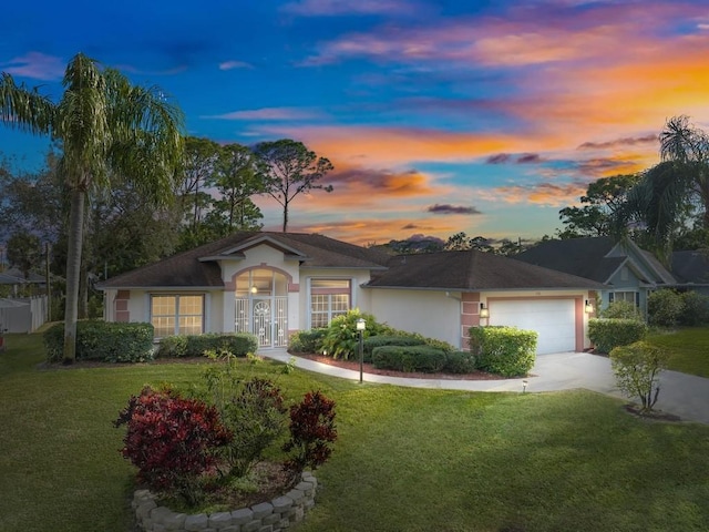 ranch-style home with french doors, a garage, and a lawn