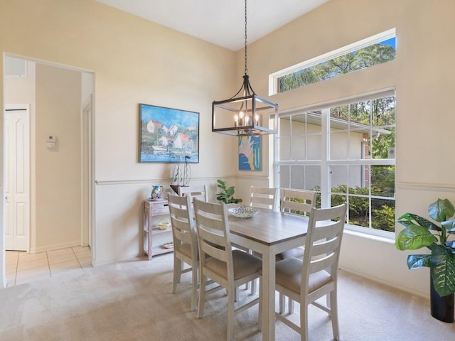 carpeted dining room featuring a chandelier