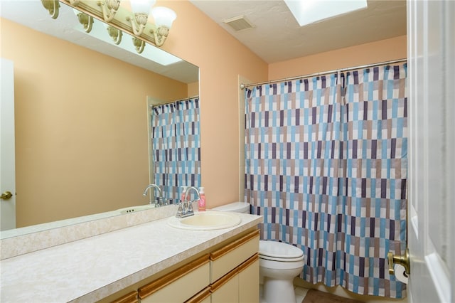 bathroom with walk in shower, vanity, and toilet