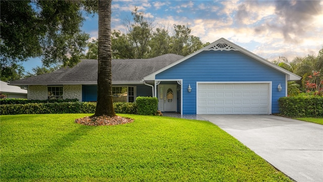 ranch-style home featuring a garage and a front lawn