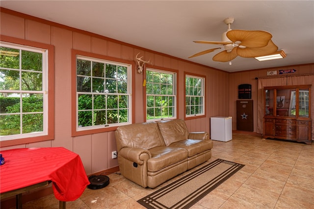 living room with ornamental molding, a wealth of natural light, and ceiling fan