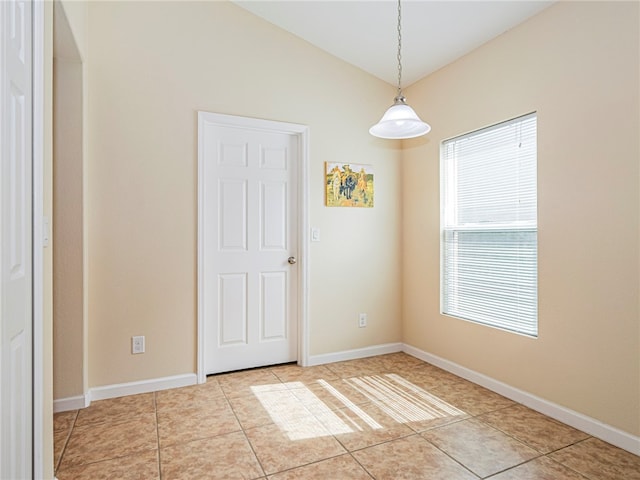 tiled empty room with lofted ceiling