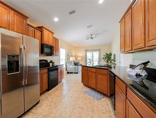 545 Valencia Cir SW, Vero Beach, FL 32968 - kitchen featuring black appliances, brown cabinetry, a peninsula, open floor plan, and recessed lighting