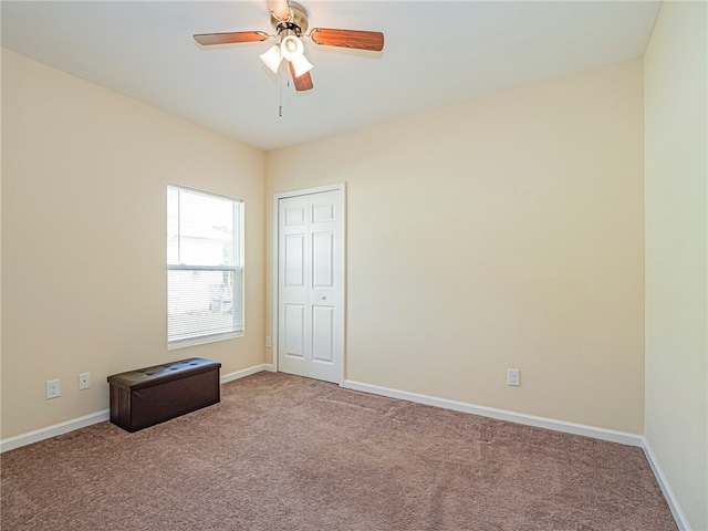 carpeted spare room with ceiling fan