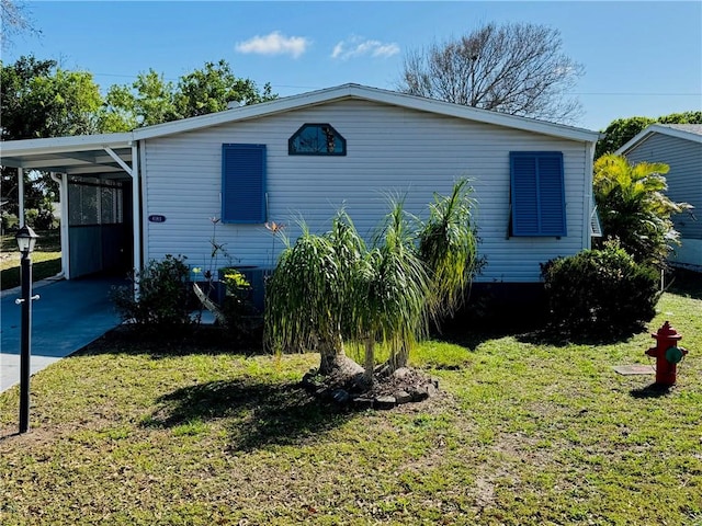 view of front facade with an attached carport, concrete driveway, and a front yard