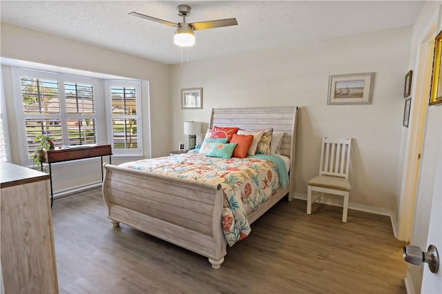 bedroom with ceiling fan, dark hardwood / wood-style flooring, and a textured ceiling