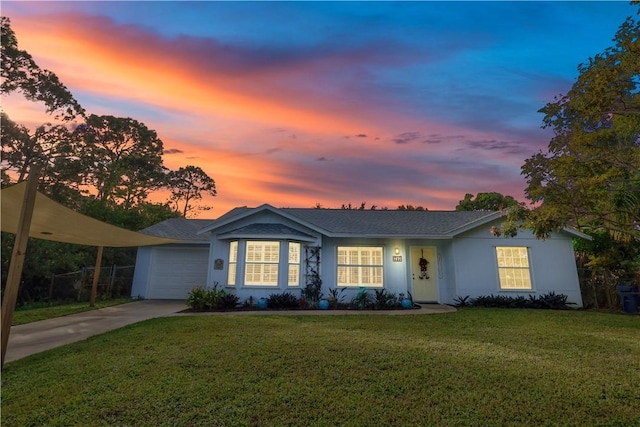 ranch-style home with a yard and a garage