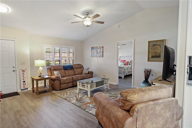 living room featuring ceiling fan, wood-type flooring, and lofted ceiling