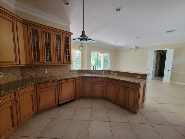 kitchen featuring pendant lighting, crown molding, sink, ceiling fan, and decorative backsplash