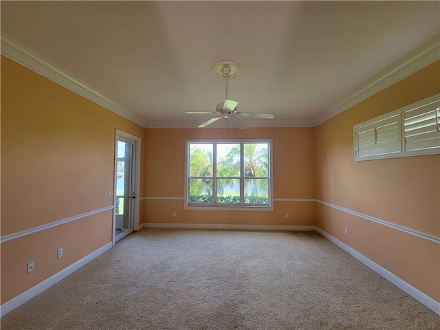 carpeted spare room featuring crown molding and ceiling fan