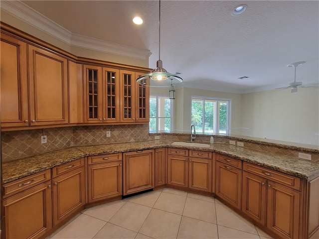 kitchen featuring a textured ceiling, ceiling fan, crown molding, sink, and hanging light fixtures