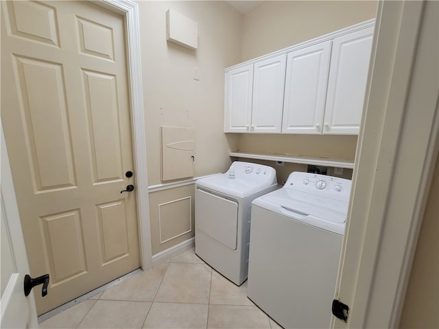 washroom featuring cabinets, light tile patterned flooring, and washer and dryer