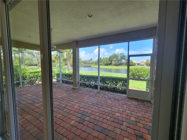 unfurnished sunroom featuring a water view and a wealth of natural light