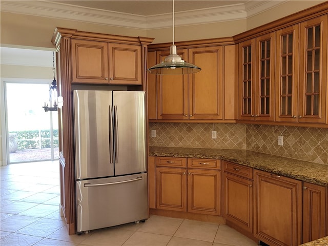 kitchen featuring pendant lighting, decorative backsplash, stainless steel fridge, ornamental molding, and stone countertops