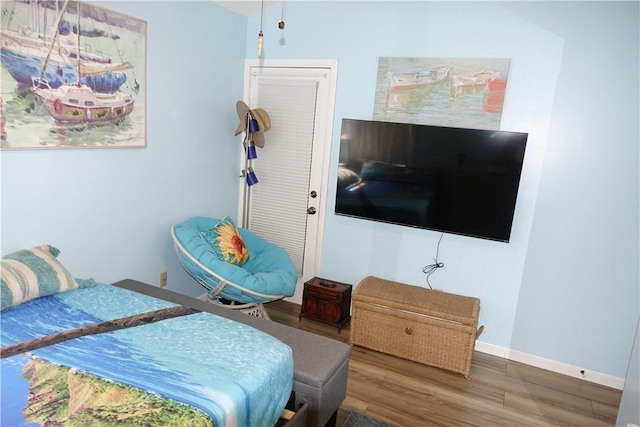 bedroom with baseboards and wood finished floors