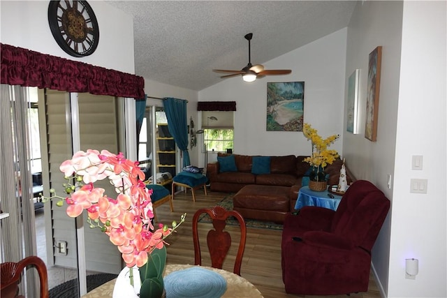 living room featuring a ceiling fan, a textured ceiling, wood finished floors, and lofted ceiling