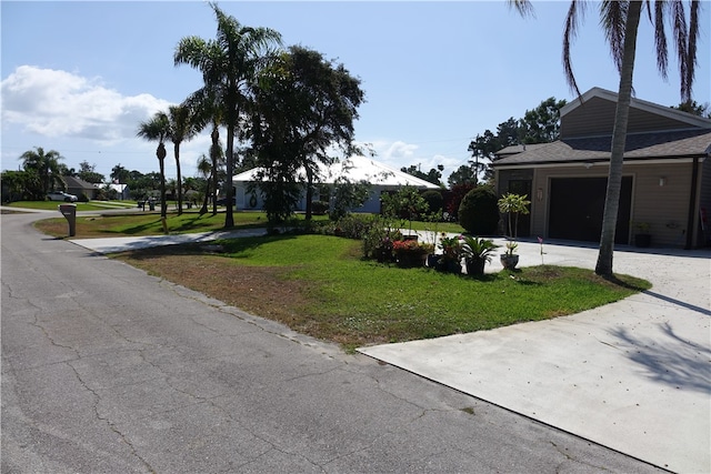 single story home featuring a garage, driveway, and a front lawn