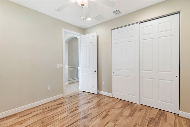 unfurnished bedroom featuring ceiling fan, a closet, and light hardwood / wood-style flooring