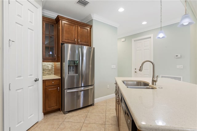 kitchen with stainless steel appliances, sink, light tile patterned floors, backsplash, and an island with sink