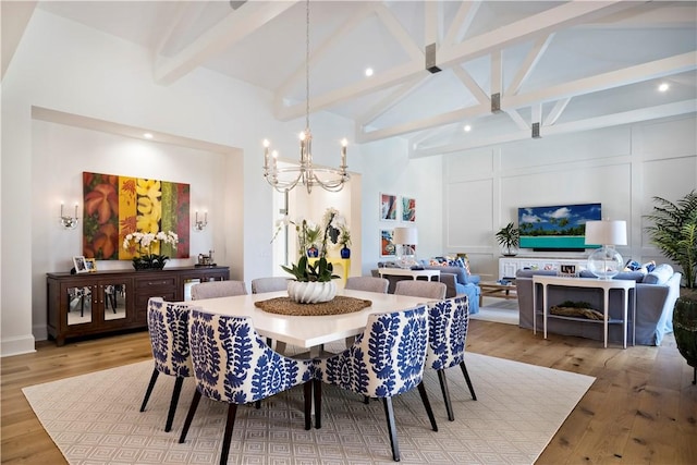 dining area featuring beam ceiling, a chandelier, high vaulted ceiling, and light hardwood / wood-style flooring