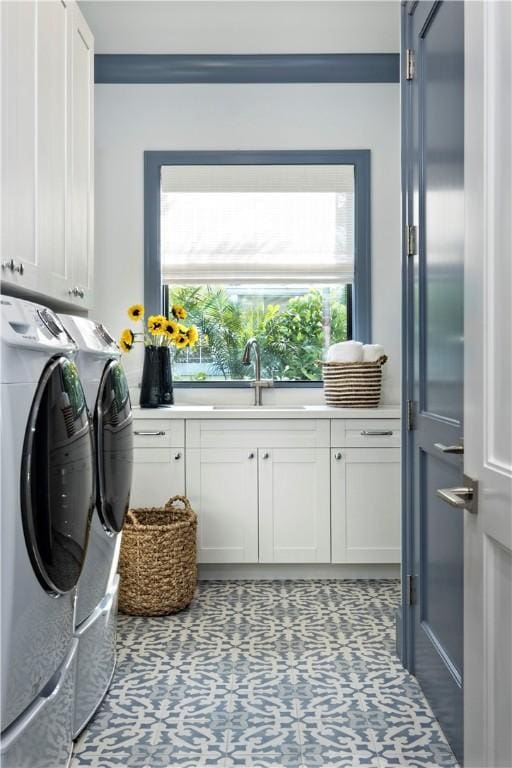 laundry room with sink, tile patterned floors, cabinets, and washing machine and clothes dryer