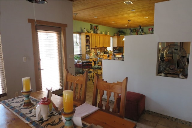 dining space with light tile patterned flooring and wooden ceiling