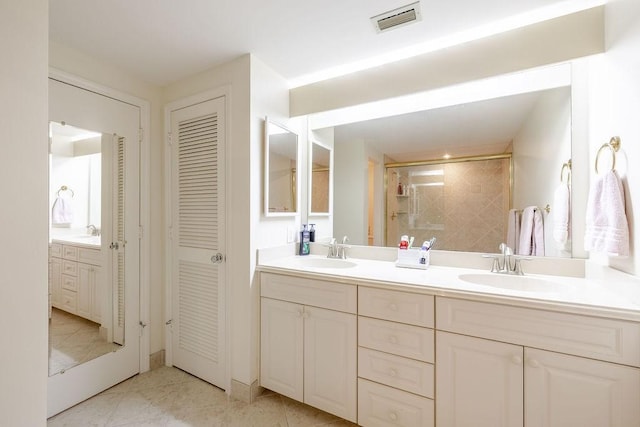 5060 Harmony Cir Unit 204, Vero Beach, FL 32967 - bathroom featuring a closet, double vanity, tiled shower, and tile patterned floors