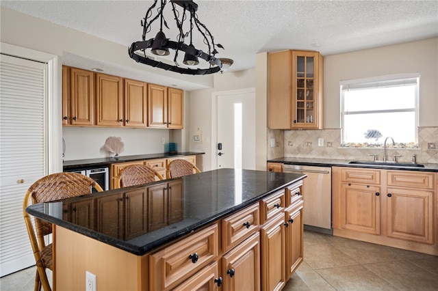 kitchen featuring dishwasher, a center island, sink, decorative light fixtures, and light tile patterned floors