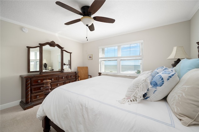 bedroom featuring a textured ceiling, light colored carpet, ceiling fan, and ornamental molding