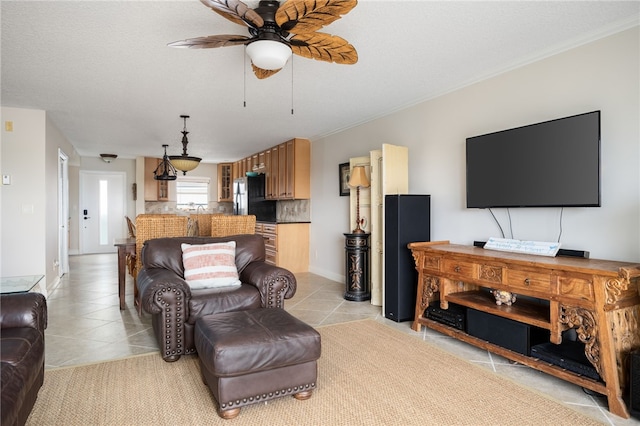 living room with ceiling fan, light tile patterned floors, and a textured ceiling