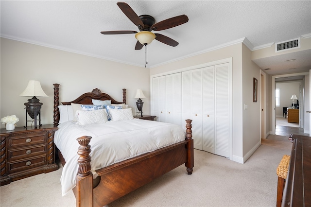 bedroom featuring ceiling fan, light colored carpet, crown molding, and a closet