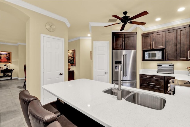 kitchen with dark brown cabinetry, appliances with stainless steel finishes, and crown molding