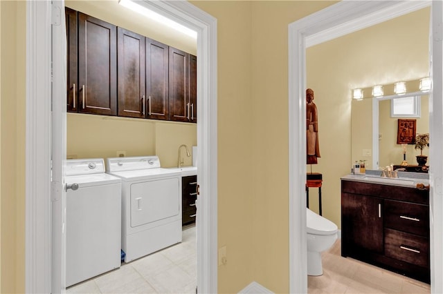 laundry area featuring sink, washer and dryer, and cabinets