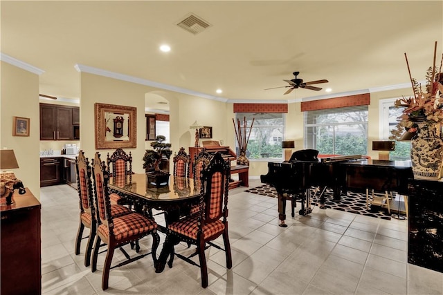 dining space with ceiling fan and crown molding