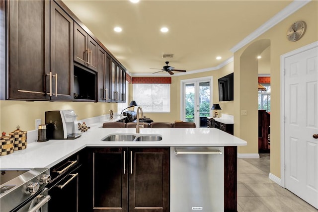 kitchen featuring kitchen peninsula, dark brown cabinets, sink, and stainless steel appliances