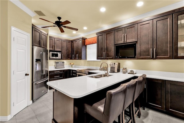 kitchen with a breakfast bar area, appliances with stainless steel finishes, kitchen peninsula, and sink