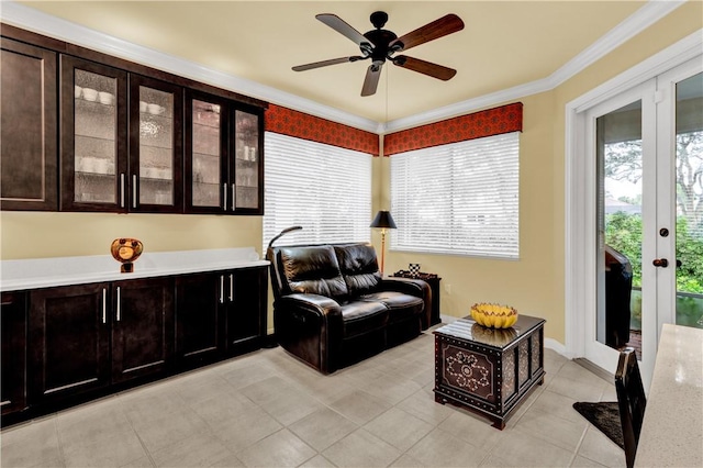 sitting room featuring ceiling fan, light tile patterned floors, crown molding, and french doors