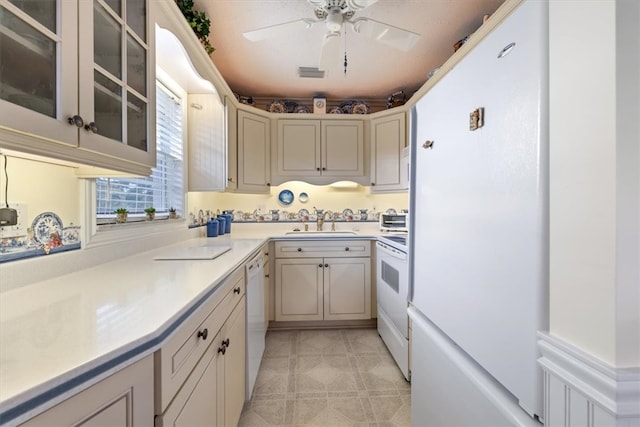 kitchen featuring white appliances, ceiling fan, and sink