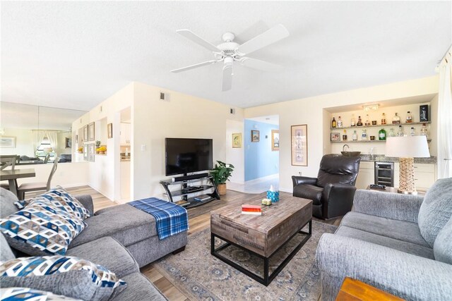 3351 Twin Lakes Ter Unit 106, Fort Pierce, FL 34951 - living room featuring wood finished floors, wine cooler, wet bar, and a ceiling fan