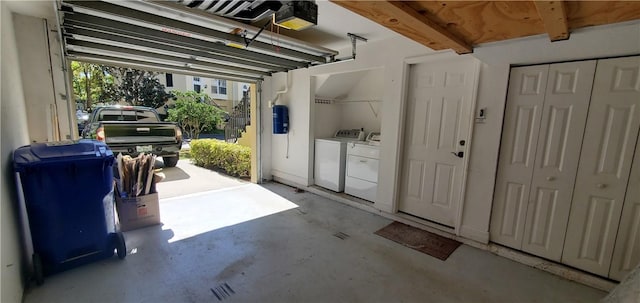 garage with washing machine and dryer and a garage door opener